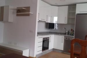 托马雷斯APART-DUPLEX-ATICO Tomares的厨房配有白色橱柜和不锈钢用具