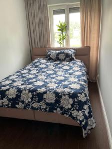 弗罗茨瓦夫Luxury Maślice Apartment的一张带蓝色和白色棉被的床和一个窗口