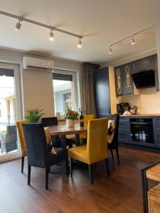 弗罗茨瓦夫Luxury Maślice Apartment的厨房以及带桌椅的用餐室。
