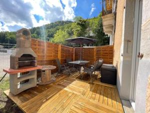 莫雷兹Sauna en bord de rivière的一个带烧烤架、桌子和遮阳伞的庭院