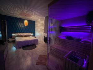 莫雷兹Sauna en bord de rivière的一间卧室配有一张床和紫色照明