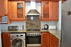 德班53 Sea Lodge Umhlanga Rocks的厨房配有炉灶和洗衣机。