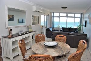 德班53 Sea Lodge Umhlanga Rocks的客厅配有沙发和桌椅
