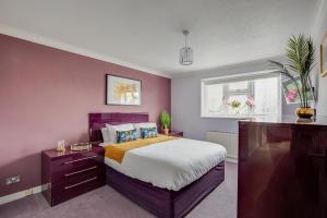斯坦维尔Ashford, Legoland, Windsor, Heathrow Serviced House的紫色卧室设有一张床和一个窗户