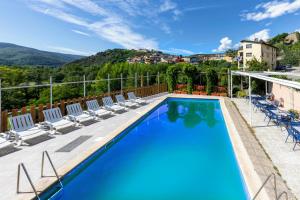 塞奥-德乌赫尔Hotel Restaurante La Glorieta的一个带椅子的游泳池,后方是一座山。