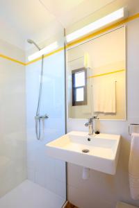 卡拉莫若尔萨考尼公寓式酒店的白色的浴室设有水槽和淋浴。