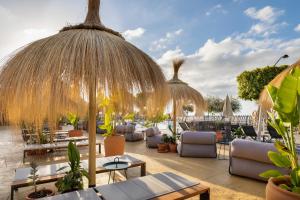 圣米格尔德阿沃纳Barceló Tenerife Royal Level的一个带桌椅和遮阳伞的度假庭院