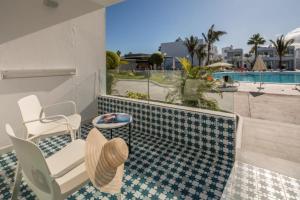 科斯塔特吉塞兰兹绿洲海滩度假村的一个带桌椅的庭院和一个游泳池