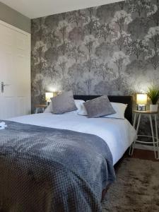 蒂斯河畔斯托克顿Hardwick Haven, Sedgefield - Near Hardwick Hall的一间卧室配有一张带花卉壁纸的大床