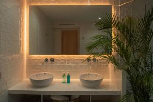 卡门港Barcarola Club的浴室在镜子前的柜台上放两个碗