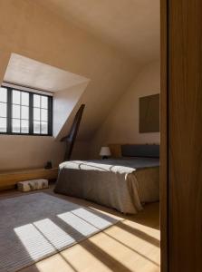 哥本哈根Audo Copenhagen的阁楼卧室设有床和窗户。
