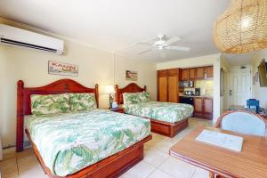 卡帕阿Islander on the Beach 111的一间卧室配有两张床和一张桌子