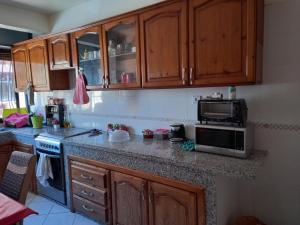 卡萨布兰卡APPARTEMENT ZENITH的厨房配有木制橱柜和微波炉。