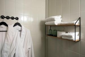 皮赫蒂普达斯Koto Hotel Pihtipudas的浴室的架子上配有白色毛巾