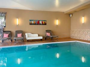 奥斯赛拜-屈隆斯博恩Wittenbeck Resort的游泳池位于酒店带椅子和沙发的客房
