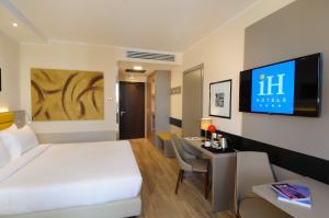米兰iH Hotels Milano Lorenteggio的配有一张床和一张书桌的酒店客房