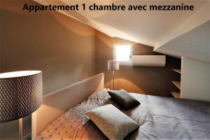 阿尔勒Holiday in Arles -Appartement du Théâtre Antique的一间卧室配有一张床和一盏灯