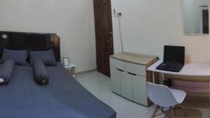 TjolomaduChoko Homestay的一间卧室配有一张床和一张带笔记本电脑的书桌