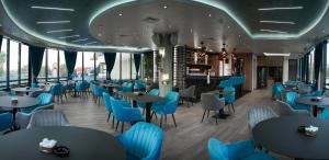 拉克塔希Hotel Laktaši的一间设有蓝色椅子和桌子的餐厅