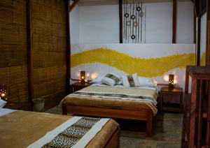 麦德林Refugio del Jaguar的一间卧室设有两张床和两张带台灯的桌子。