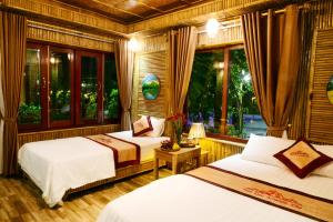宁平Tam Coc Amanda Villas的一间卧室设有两张床和窗户。