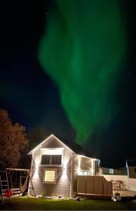 安德内斯Sauna House的天空中绿意盎然的北极光度假屋