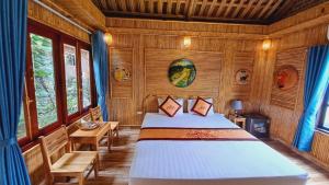 宁平Tam Coc Amanda Villas的木制客房内的一间卧室,配有一张床