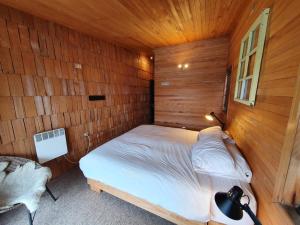 卡斯特鲁Hotel & Café Bauda的卧室配有木墙内的一张床
