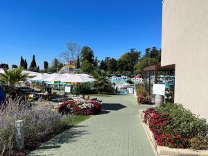 巴多利诺Sisan Family Resort的一个带桌子、遮阳伞和鲜花的庭院