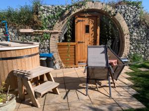 希尔内斯Romantic escape luxury Hobbit house with Hot tub!的一个带椅子和桌子的庭院和一座建筑