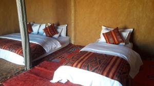 AdrouineSaharaTime Camp的一间卧室配有两张床和镜子