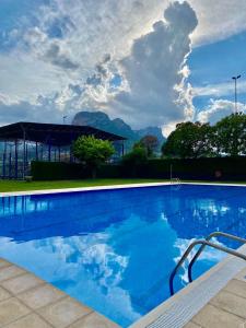 奥尔加尼亚Càmping Organyà Park的一个大型蓝色游泳池,后面是群山