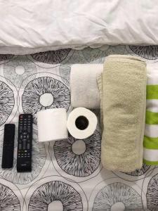 宿务CHE & JAMES FEMALE GUEST House COLON, CEBU的一张带毛巾和卫生纸的床以及遥控器