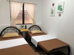 科隆Hiraya Homestay Coron的带窗户的客房内的两张床