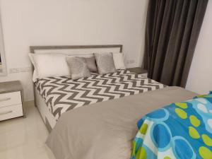 塞拉莱Hawana Salalah Laguna Studio的卧室配有一张带白色和灰色枕头的大床
