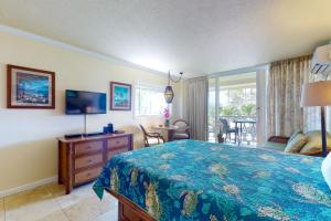 卡帕阿Islander on the Beach 333的一间卧室配有一张床、一台电视和一张桌子