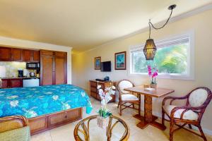 卡帕阿Islander on the Beach 333的卧室配有一张床和一张桌子及椅子
