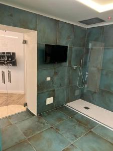 那不勒斯Real Giardinetto a Toledo的带淋浴的浴室和墙上的电视