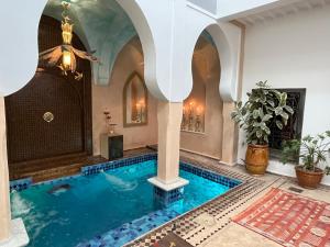 马拉喀什Riad Al Ibtikar的一座带拱门的房子中的游泳池