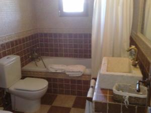 Caspueñas克普利由郊区艾尔玛兰艾尔酒店的浴室配有卫生间、浴缸和水槽。