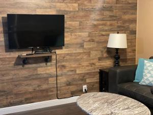 布尔海德市Relaxing River Family Retreat的客厅设有木墙,配有电视