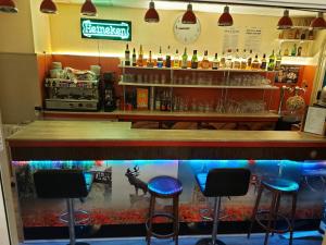 阿尔贝德拉帕酒店的鱼缸前有四把凳子的酒吧