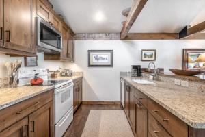 杰克逊Golf Creek 31的厨房配有木制橱柜和白色家电