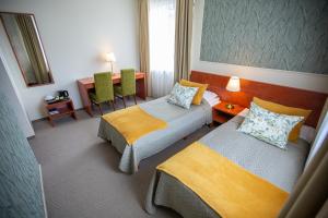 伊格纳利纳苏维德拉酒店的酒店客房设有两张床和一张桌子。