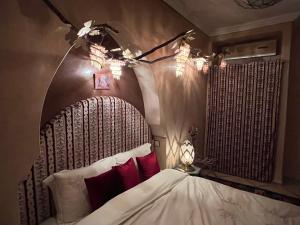 马拉喀什Riad Al Ibtikar的一间卧室配有一张带木制床头板的床