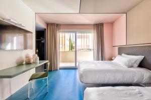里米尼Open Hotel的配有粉红色墙壁和蓝色地板的客房内的两张床