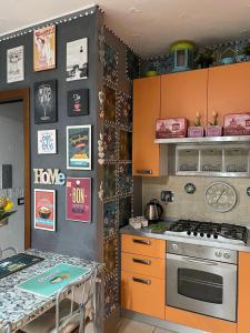 雷诺河畔卡萨莱基奥艾莉之家公寓的厨房配有橙色橱柜和炉灶。