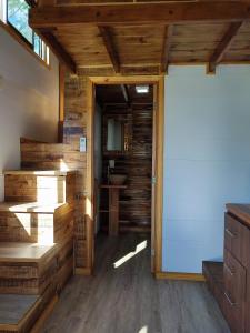 蒙特卡洛Tiny House Nativa的木墙房间的一扇开放式门