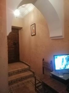 马拉喀什Hostel Laksour的客厅配有电视、桌子和门