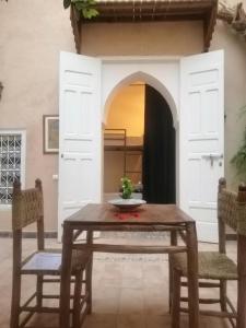 马拉喀什Hostel Laksour的一间带桌子和两把椅子的用餐室